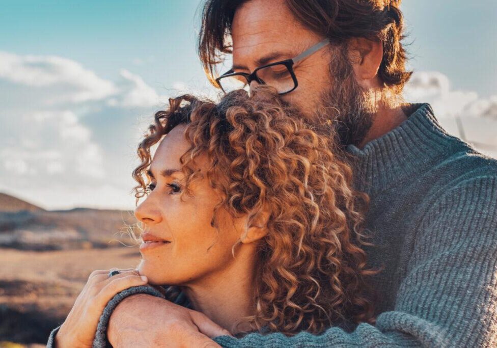 Young adult couple in love in outdoor leisure activity admiring travel destination. Contemplation. People traveler and adventure lifestyle. Man hug woman from behind. Looking away, togetherness two relationship counseling reno, nv with Cornelius Sheehan, LCSW. couple counseling clients embrace, outdoors. Therapy in Reno