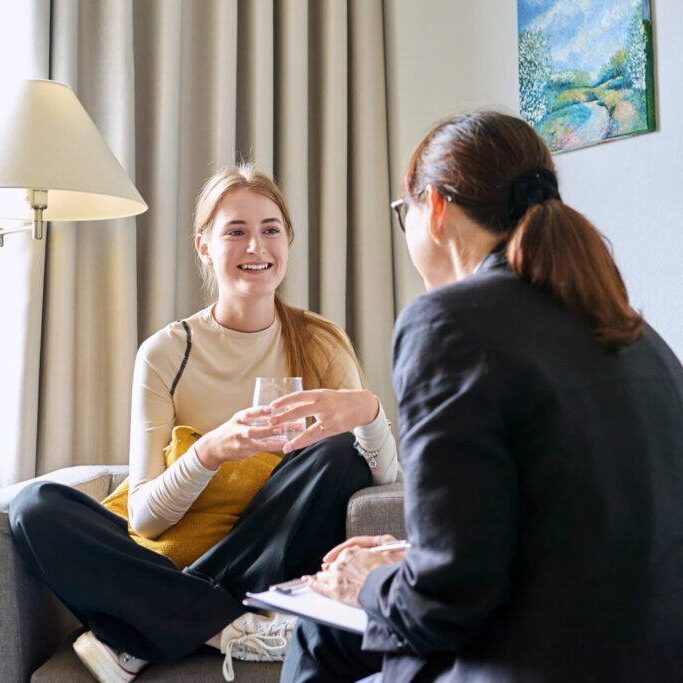 Young woman talking with counselor young woman in therapy for relationship counseling